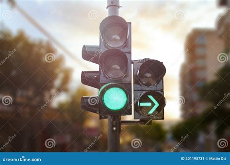 Green Traffic Light with Green Arrow Light Up in City while Sunset Allows Car To Turn Right ...