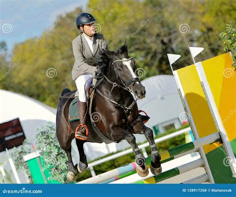 Black Horse and Girl in Uniform at Show Jumping Competition. Stock ...