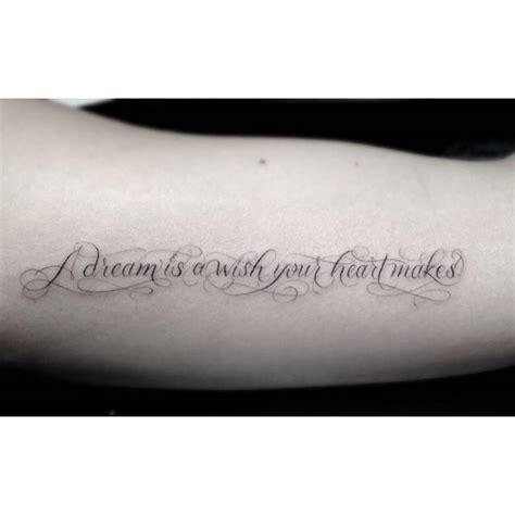 Inner arm tattoo saying "A dream is a wish your heart