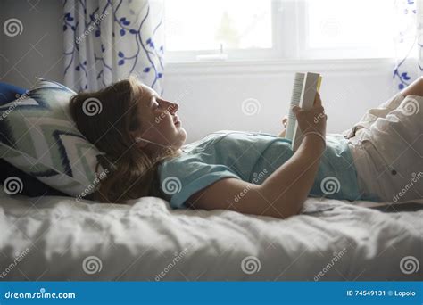 Girl Lying on Bed and Reading Book. Stock Image - Image of home, childhood: 74549131