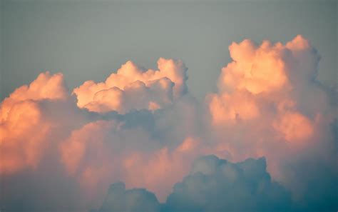 Fluffy cumulus clouds in gray sky on sunrise · Free Stock Photo