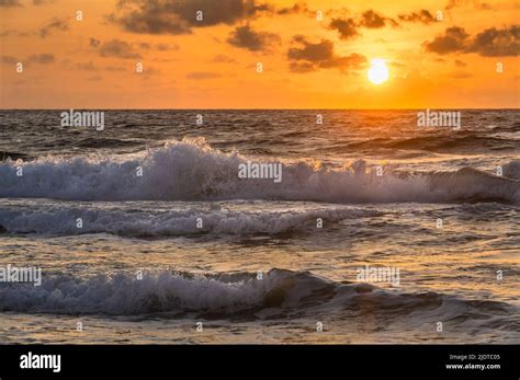 Ocean waves at sunrise Stock Photo - Alamy