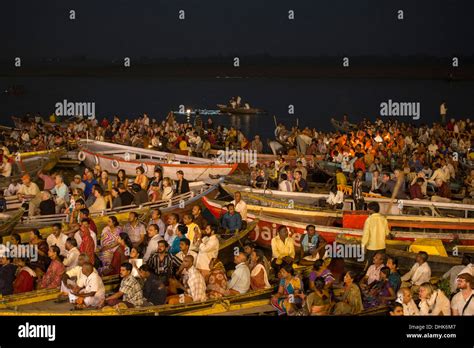 Crowds in boats admire evening Aarti prayer ceremony at Dasaswamedh Ghat alongside Ganges river ...