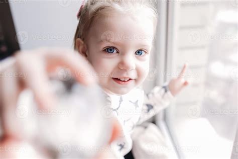 Little girl sitting near the window 11445993 Stock Photo at Vecteezy