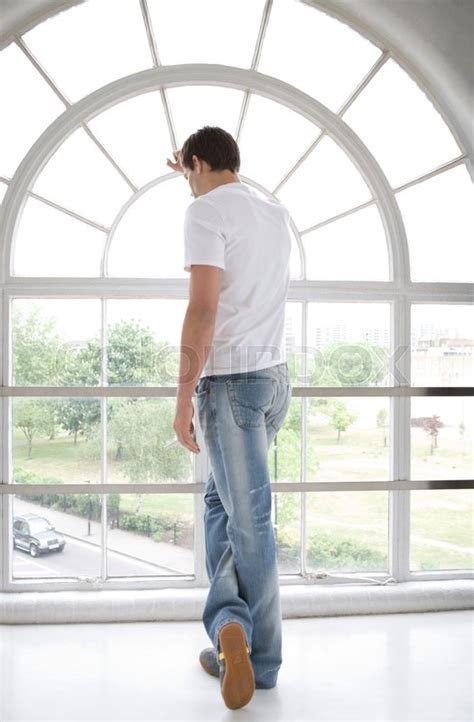 Man looking through a window. | Stock image | Colourbox