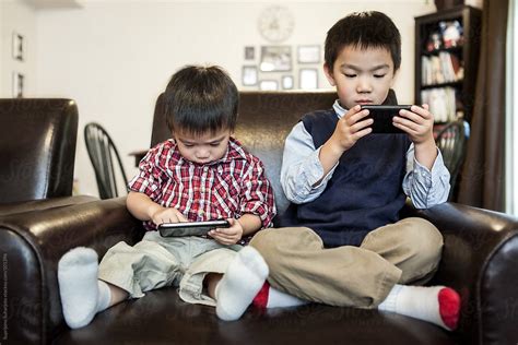 "Asian Kids Playing Game At Home On The Cell Phones" by Stocksy ...