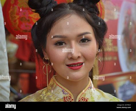 Young Thai Chinese beauty with trendy contact lenses and traditional double side buns wears a ...