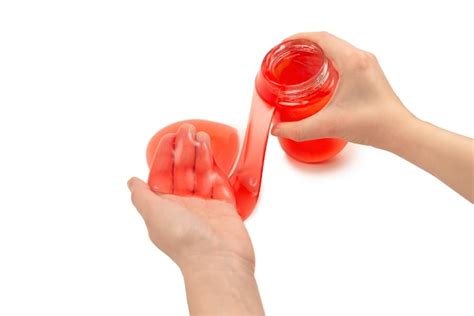 Premium Photo | Red slime toy in woman hand isolated on white top view