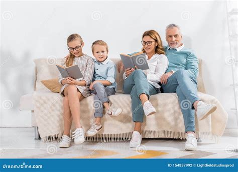 Grandchildren and Grandparents Reading Books on Sofa Stock Photo ...