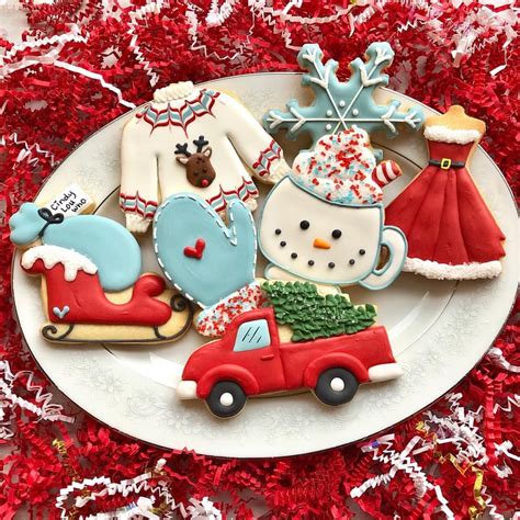 decorated christmas cookies on a plate with red tinsel