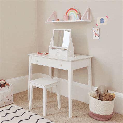 a child's desk with a mirror, toy chest and teddy bear on it