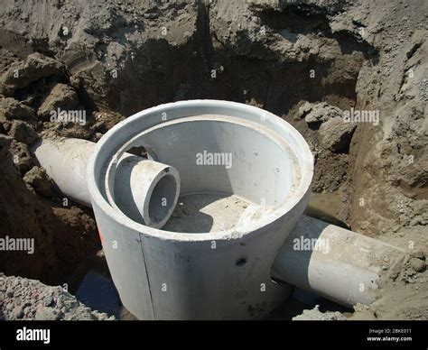 Precast concrete manhole with two pass through pipe connections Stock Photo - Alamy