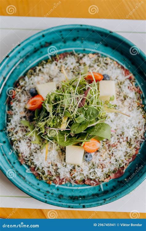 Beef Carpaccio with Pesto Sauce and Parmigiano Cheese Decorated by Salad and Fruit. Restaurant ...