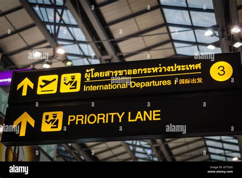 Priority Lane - illuminated yellow sign at airport Stock Photo - Alamy