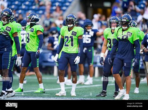 Members of the Seattle Seahawks defense, including cornerback Devon Witherspoon (21), warm up ...