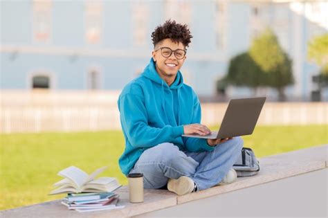 Premium Photo | Cheerful student working on laptop outdoors