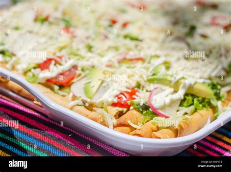 Traditional mexican chicken tacos with salad on top served on a tray ...