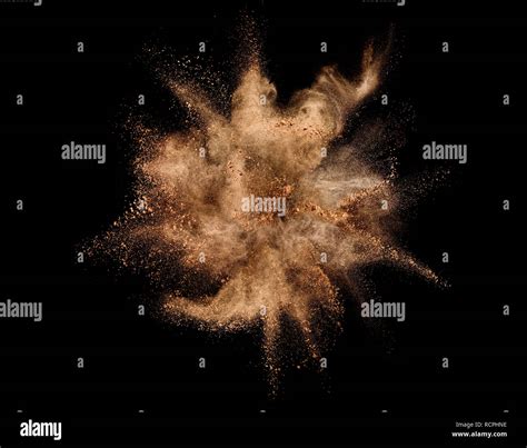 Explosion of brown powder on black background Stock Photo - Alamy