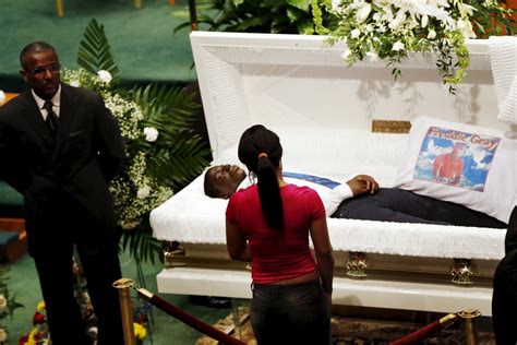 A mourner stands in front of open casket of 25-year old Freddie Gray ...