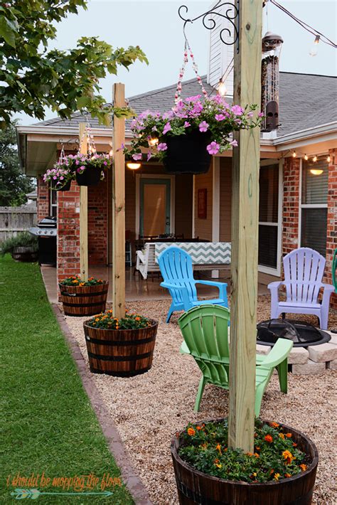 garden posts with hanging pots and light strings | Diy patio, Diy backyard, Backyard projects