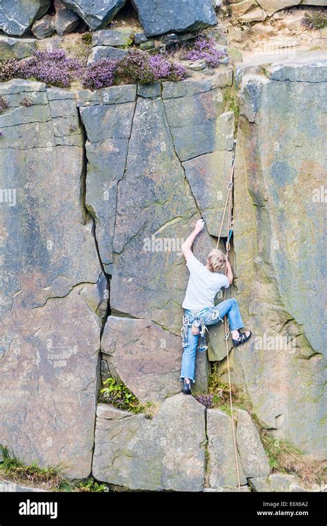 Climbing up the Cow and Calf rock face on Ilkley Moor West Yorkshire ...