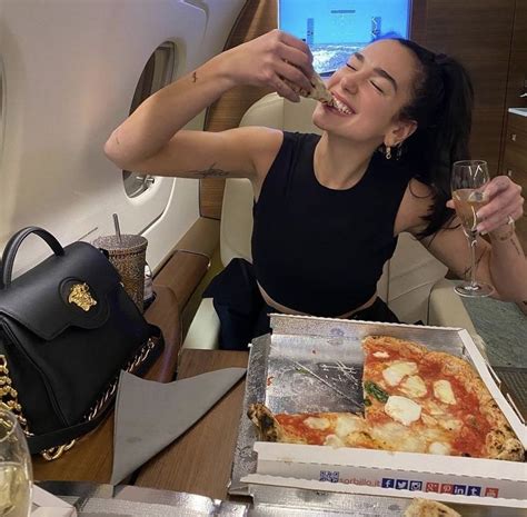 Dua lipa posing for an instagram picture, eating pizza on a private jet ...