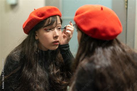 Young elegant girl doing her makeup with eyeliner Stock Photo | Adobe Stock