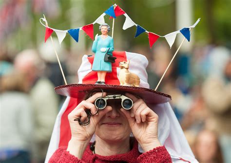 A woman in a fancy dress hat featuring Queen Elizabeth II and a corgi