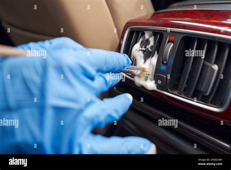 Worker cleaning automobile air conditioner vent grill with brush Stock Photo - Alamy