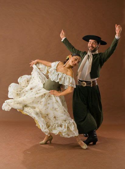 a man and woman dressed in old fashioned clothing are dancing with their arms raised up