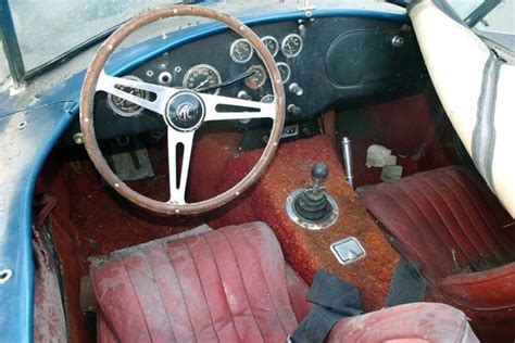 the interior of an old car with red leather seats and steering wheel, including dashboard