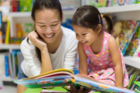 Parent and child reading books together in the library. - CERIC