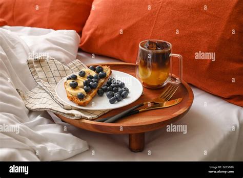 Wooden tray with delicious breakfast and cup of coffee on bed Stock Photo - Alamy