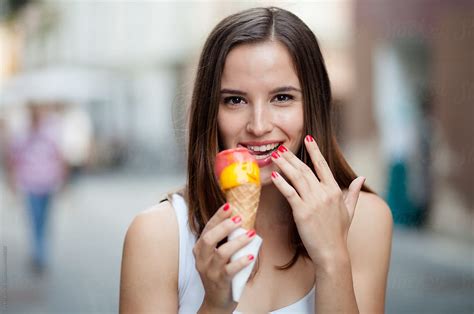 Young Woman Eating Ice Cream On The Street | Stocksy United