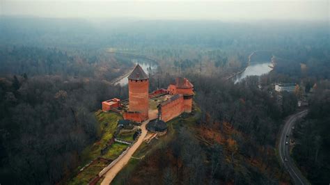 Drone flying low over ancient Turaida castle and museum reserve in Sigulda, Latvia, autumn foggy ...