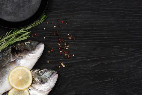 Premium Photo | Fresh fish dorado dorado and ingredients for cooking on a table