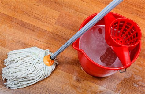 cleaning of wet floors by mop and red bucket with washing water - Living Well Spending Less®