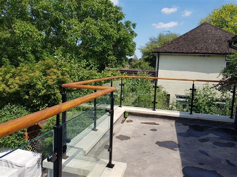 Our powdercoated glass balustrade system with timber iroko handrail supplied and installed on a ...