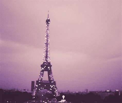 the eiffel tower is lit up at night with lights on it's sides