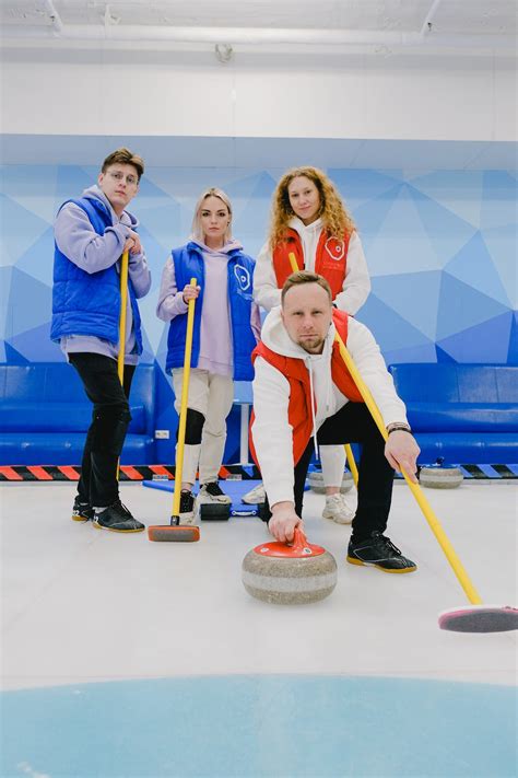 Curling team with equipment on ice · Free Stock Photo