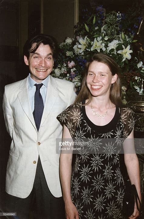 a young man and woman standing next to each other in front of a floral ...