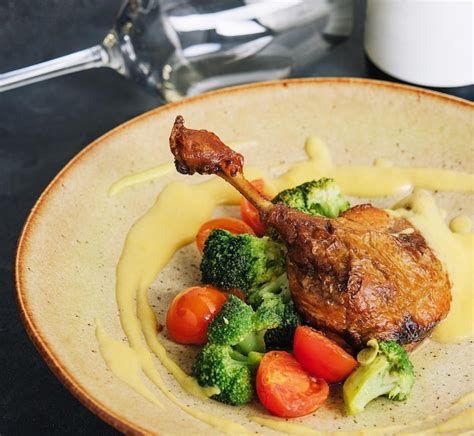 Premium Photo | Confit duck leg with broccoli and tomatoes