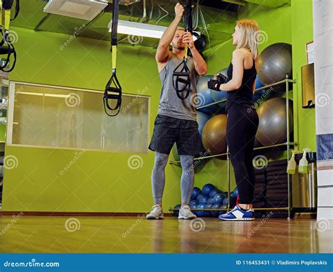 Sporty Male and Female Doing Trx Straps Exercises in a Gym Club. Stock ...