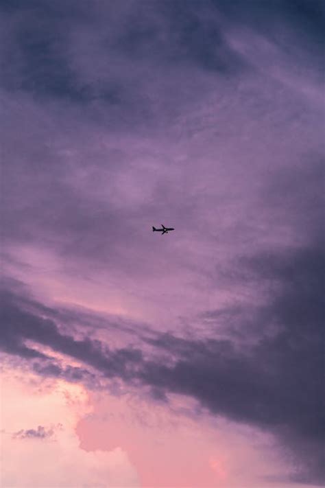 Airplane in a Purple Sky with Clouds · Free Stock Photo