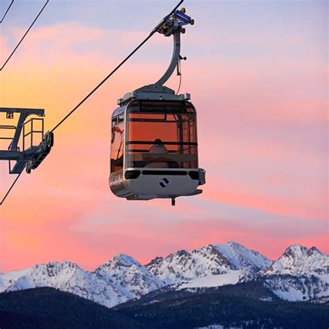 a gondola with mountains in the background at sunset