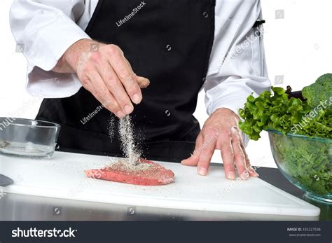 Cook / Chef Sprinkling Salt, Pepper, And Spices On Meat Stock Photo ...