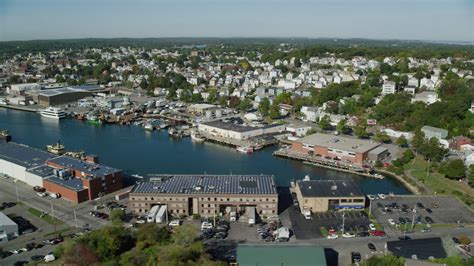 6k stock footage aerial video flying by coastal town, warehouses, Gloucester, Massachusetts ...