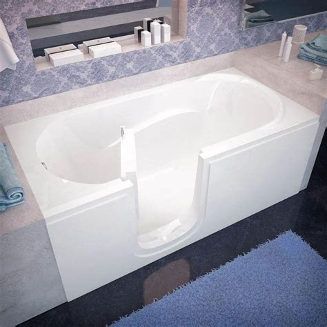 a bath tub sitting next to a sink in a bathroom with blue rugs on the floor