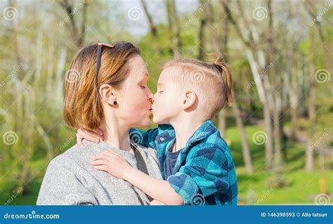 La Maman Embrasse Son Garçon En Parc Au Printemps Image stock - Image du blonde, drôle: 146398593