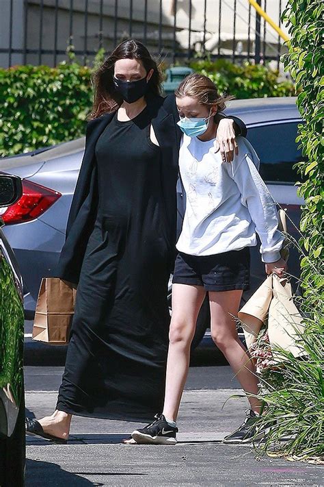 Angelina Jolie without make-up and without a bra walks hugging her daughter Vivienne